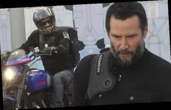 Keanu Reeves sports a graying beard as he rides his motorcycle