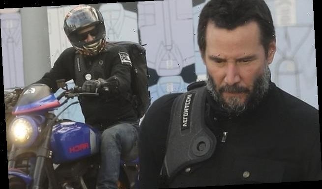 Keanu Reeves sports a graying beard as he rides his motorcycle