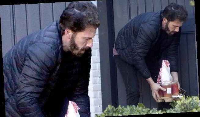 Ben Affleck emerges from his house to pick up a Dunkin' Donuts order