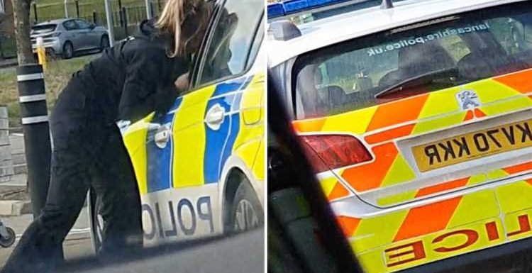 Two cops caught KISSING in patrol car forced to apologise after driver films their twenty minute snog session