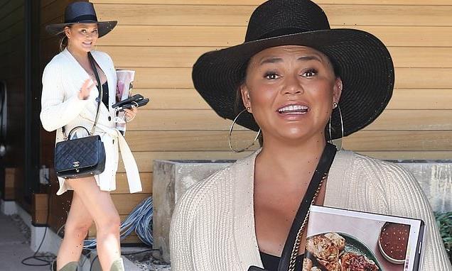 Chrissy Teigen beams in black fedora and cardigan to visit LA office