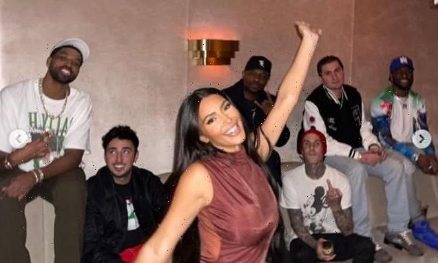 Kim Kardashian poses in front of her sisters' boyfriends