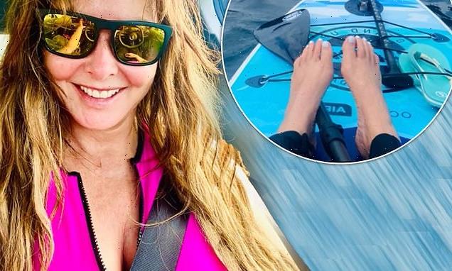Carol Vorderman teases a glimpse of cleavage while paddle boarding