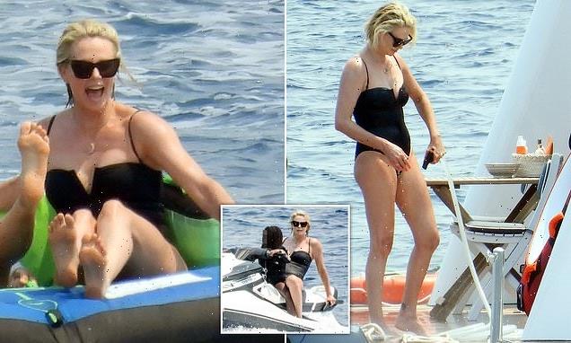 Charlize Theron looks incredible in a figure-hugging black swimsuit