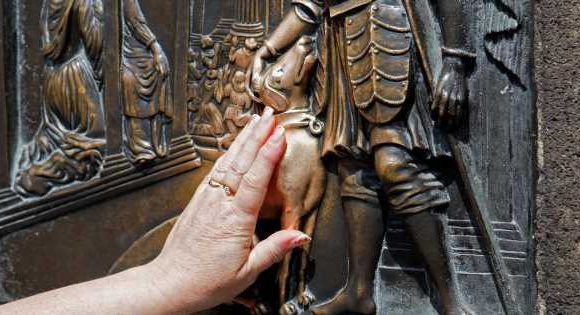 Dog carving glows gold from people petting it thousands of times