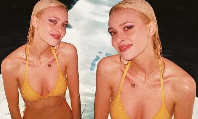 Nicola Peltz poses in a pool wearing a skimpy yellow bikini