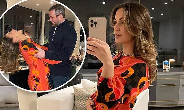 Sam Faiers cradles her growing baby bump in a psychedelic orange dress