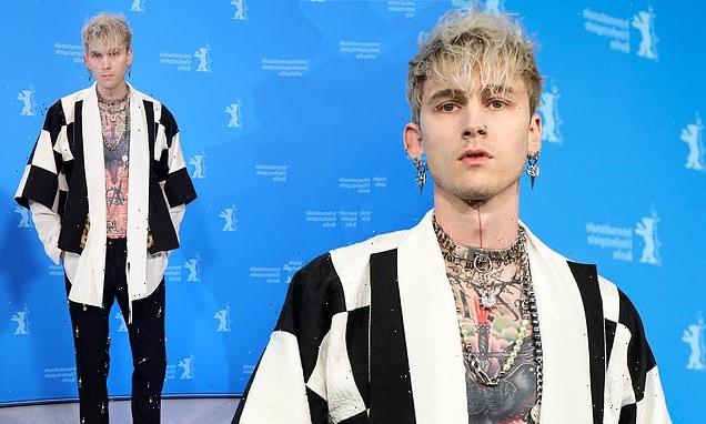 Machine Gun Kelly bares his tattooed chest for the premiere of Taurus
