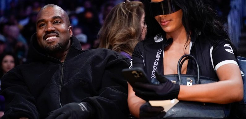 Kanye West salutes the crowd as he takes his Kim Kardashian clone girlfriend Chaney Jones to watch the LA Lakers