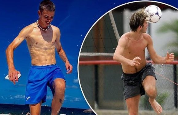 Romeo Beckham goes shirtless while kicking football on beach in Miami