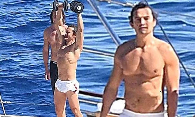 Shirtless Orlando Bloom lifts weights on a yacht in Italy