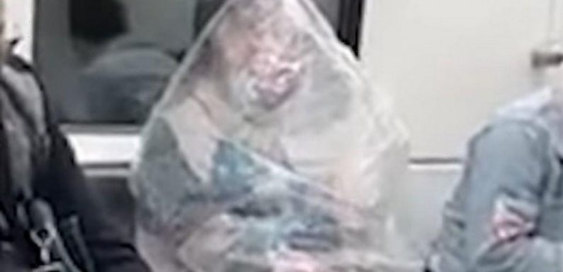 Starving woman consumes banana while wrapped in a massive plastic bag