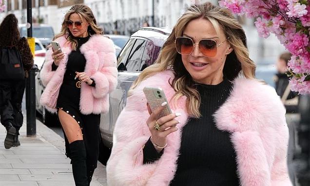 Lizzie Cundy dons a black thigh-split dress and pink fluffy jacket