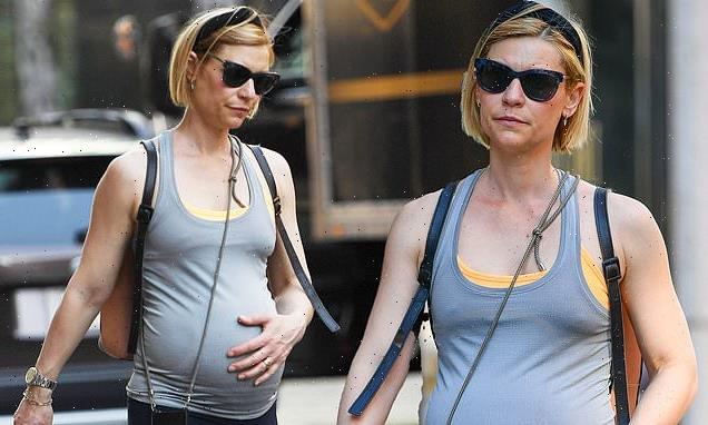Claire Danes cradles her baby bump while on a stroll in New York City