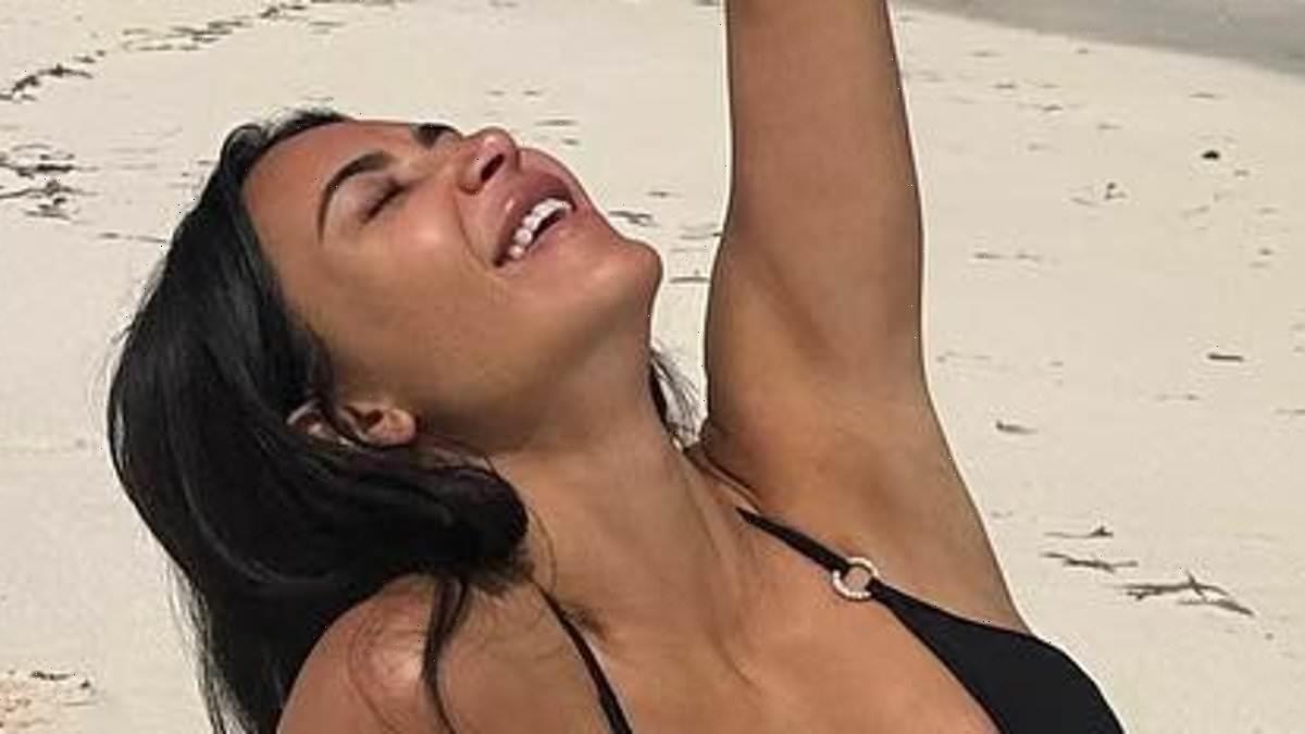 Kim Kardashian shows off her jaw-dropping figure in busty black bikini