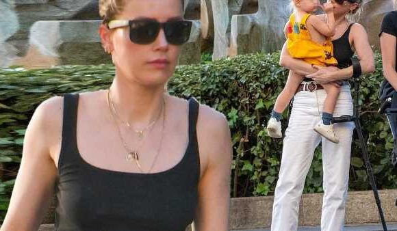 Amber Heard walks with a crutch while out with her daughter in Madrid