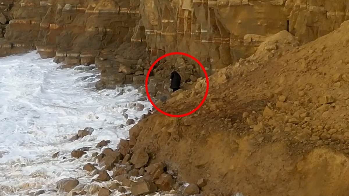 Moment mystery hooded figure risks death to climb over huge rockfall
