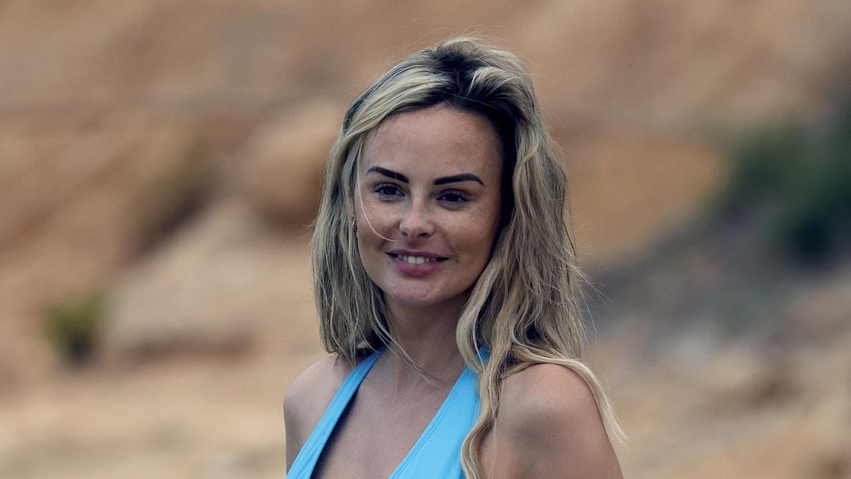 Pregnant Rhian Sugden cradles her bump on a beach day in Majorca
